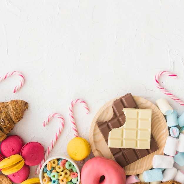 High angle view of various sweet foods on white background