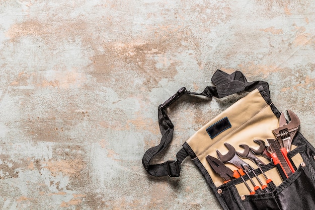 High angle view of various tools in toolbag on old wooden background