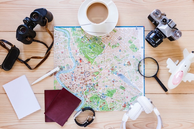 High angle view of various traveler accessories and cup of tea on wooden surface