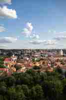 Foto gratuita veduta dall'alto di vilnius, circondata da edifici e vegetazione sotto la luce del sole in lituania