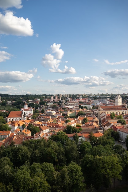 High angle view of Vilnius surrounded by buildings and greenery under sunlight in Lithuania