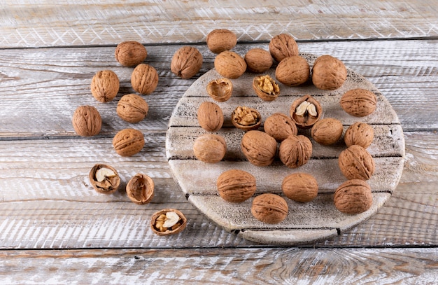 High angle view walnuts on wooden cutting board on wooden horizontal