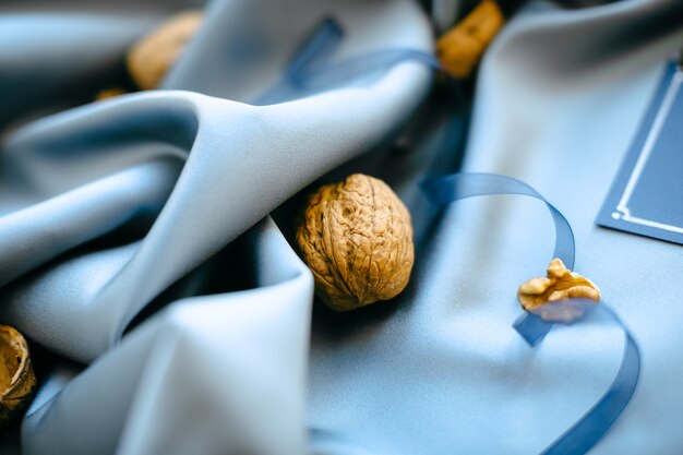 Украшения свадьбы взгляда высокого угла с гайками на голубой предпосылке ткани. горизонтальный