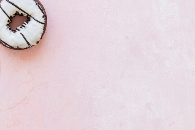 High angle view of white chocolate donut on pink background