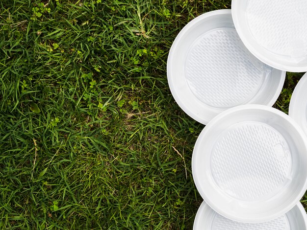 High angle view of white plastic empty plate on grass