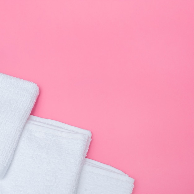 High angle view of white towels on pink background