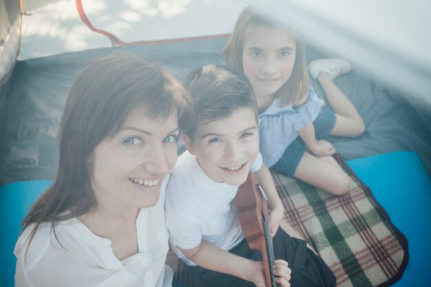 High angle view of woman and her children sitting in tent