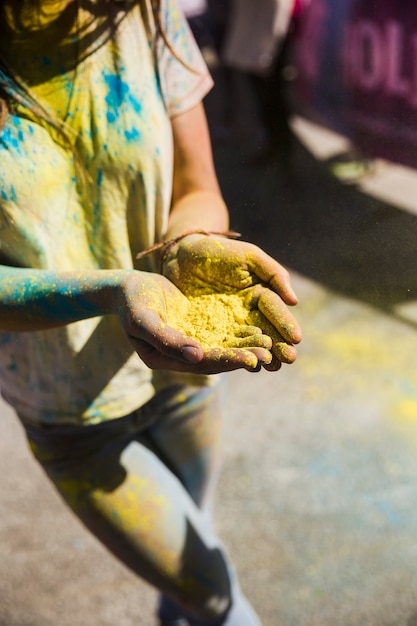 Free photo high angle view of a woman holding yellow color in hand