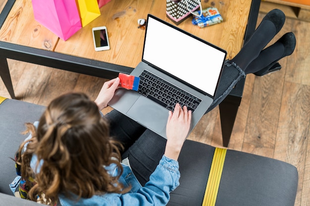 Foto gratuita punto di vista dell'angolo alto di una donna che per mezzo del computer portatile per acquisto online