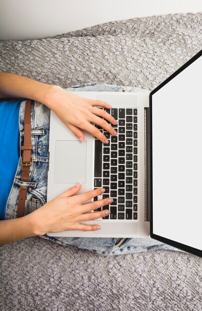 High angle view of a woman using laptop with blank white screen