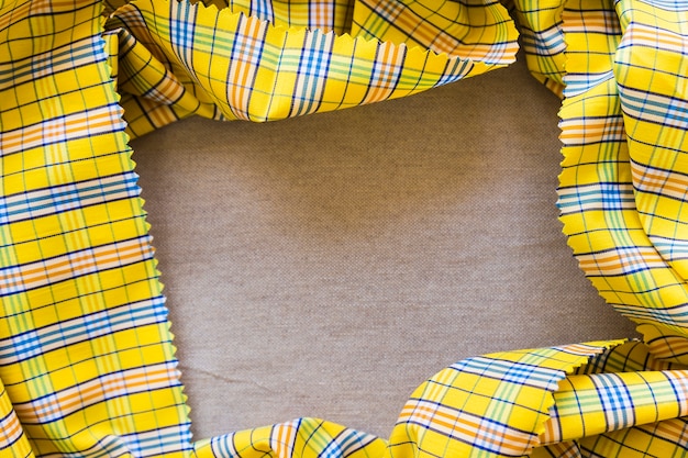 High angle view of yellow chequered pattern table cloth forming frame