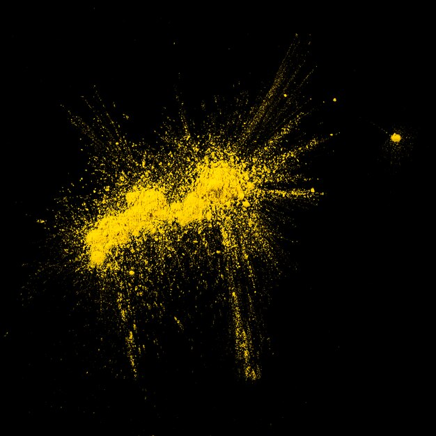 High angle view of yellow holi powder on black backdrop