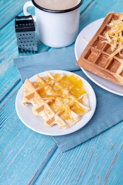 High angle of waffles on plate with grated cheese