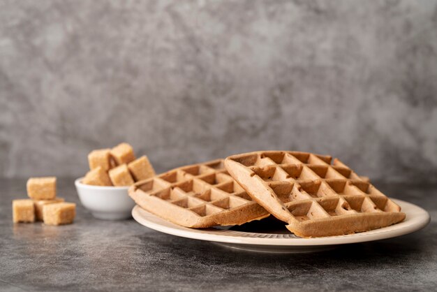 High angle of waffles on plate with sugar cubes and copy space