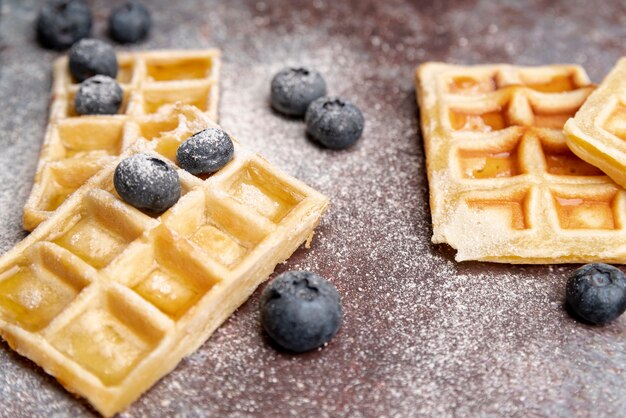 High angle of waffles with blueberries and powdered sugar