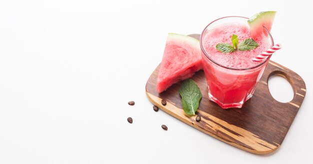 High angle of  watermelon cocktail glass on chopping board with copy space