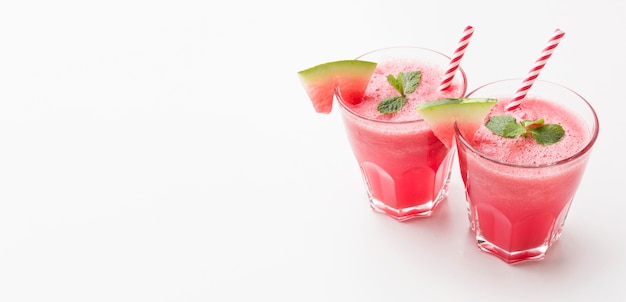 High angle of watermelon cocktail glasses with straws and mint