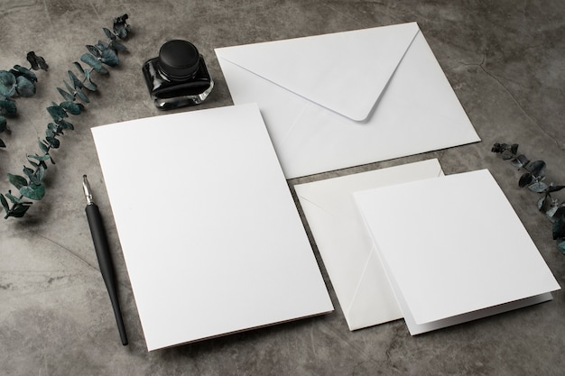 High angle of wedding paper and envelope with ink and pen