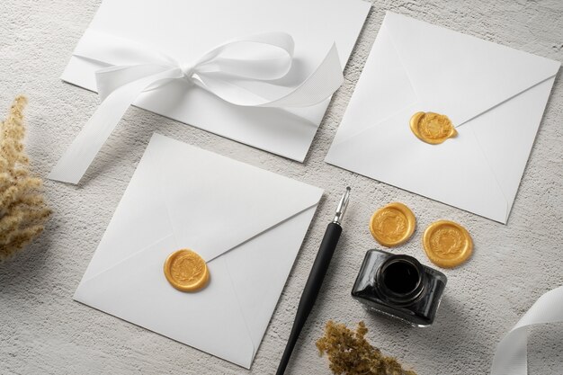 High angle of wedding paper and envelope with seal and ribbon