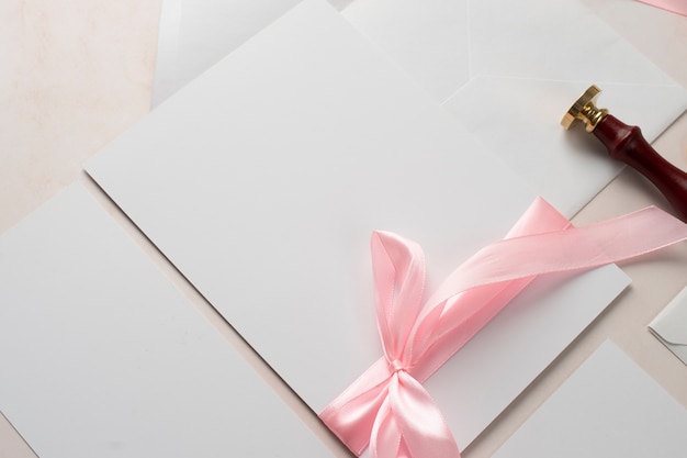 High angle of wedding paper with stamp and ribbon