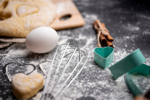 High angle of whisk and egg with dough for valentines day
