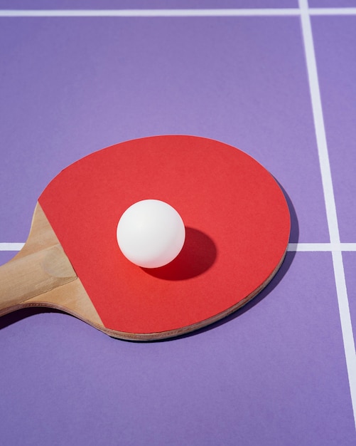 Free photo high angle white ball on ping pong paddle