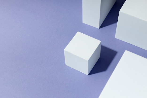 Набор белых кубиков под высоким углом на фиолетовом фоне
