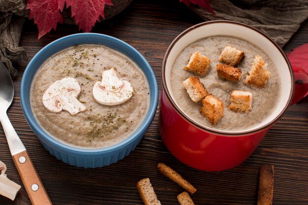 High angle of winter mushroom soup in mug and bowl with croutons