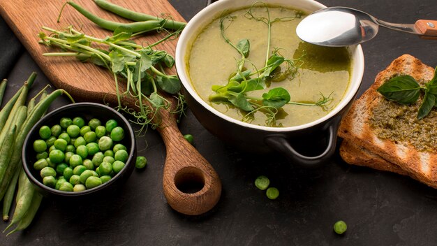 High angle of winter peas soup in bowl with toast and spoon