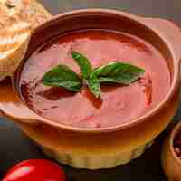 Foto gratuita alto angolo di zuppa di pomodoro invernale in una ciotola con pane