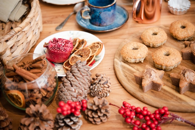 High angle of winterberry with pine cones and cookies