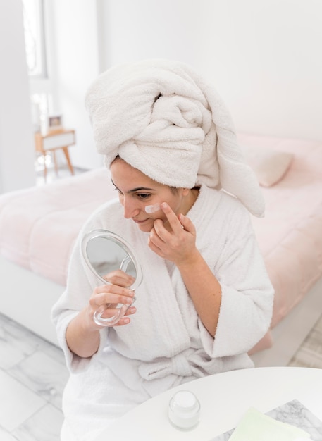 High angle woman applying face cream