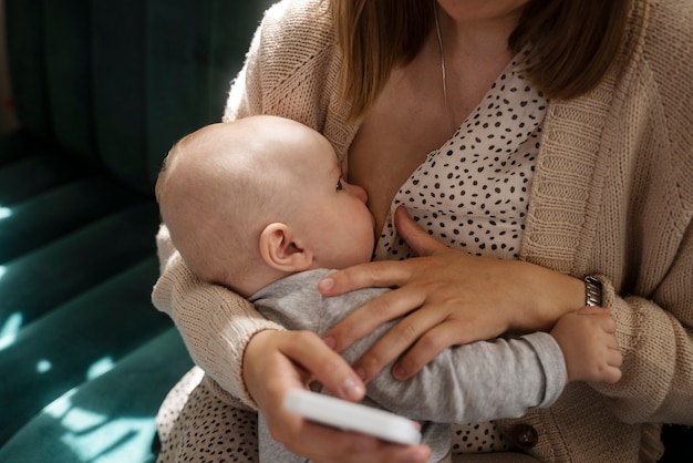 無料写真 室内で赤ちゃんを母乳で育てる高角度の女性