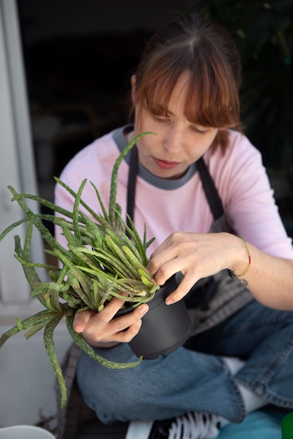 Женщина под большим углом проверяет растение