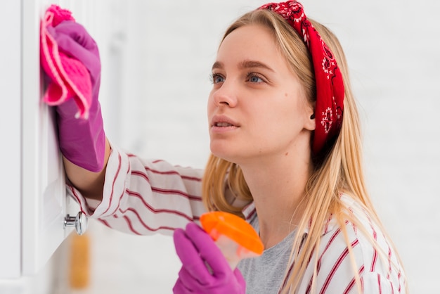 High angle woman cleaning walls at home