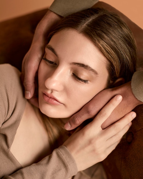 High angle of woman on the couch with man touching her face