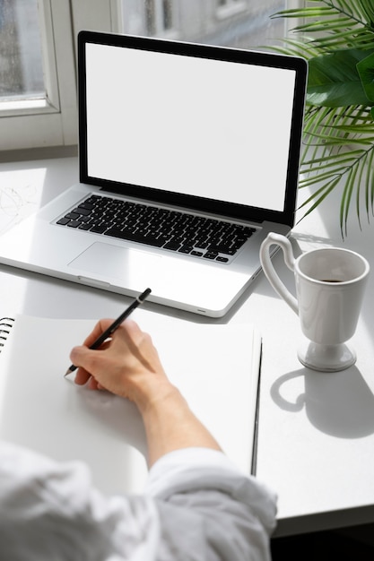 Free photo high angle of woman drawing at desk with laptop