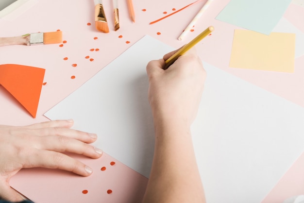 High angle of woman drawing with yellow pencil