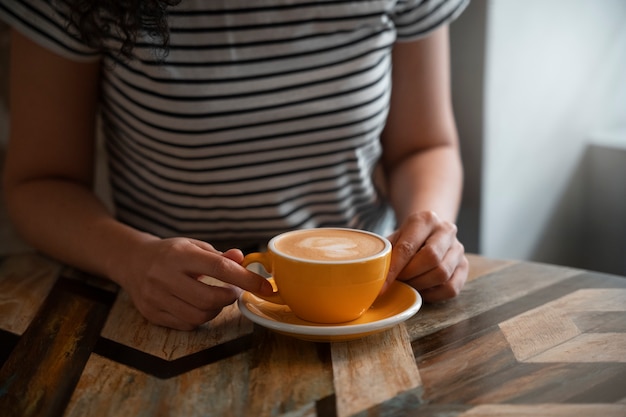 Foto gratuita donna dell'angolo alto che beve caffè