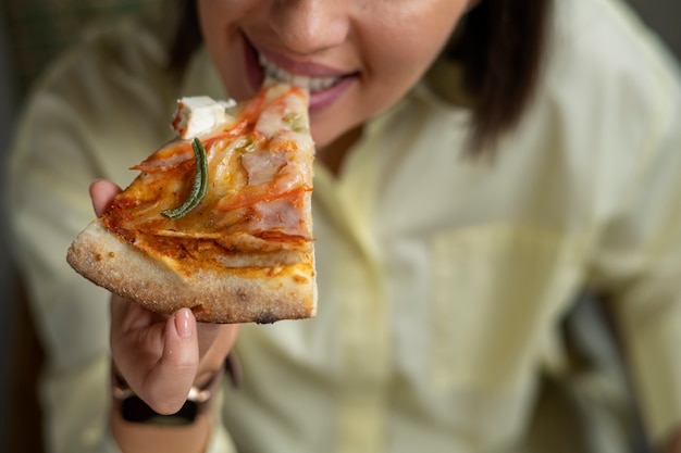 High angle woman eating delicious pizza