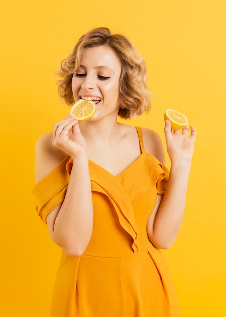 Высокий угол женщина ест лимон