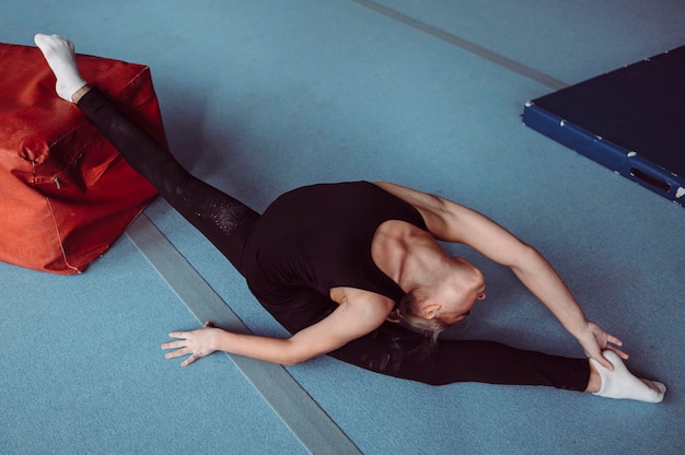 Бесплатное фото Женщина с высоким углом, тренирующаяся на олимпийских играх по гимнастике