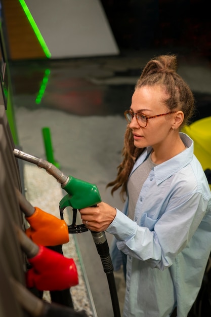 Free photo high angle woman at gas station