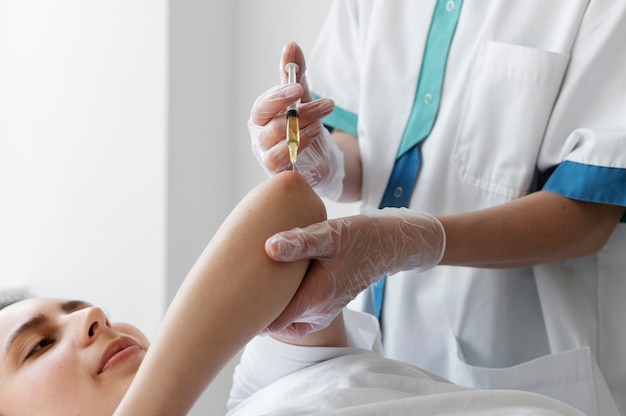 high angle woman getting elbow prp treatment