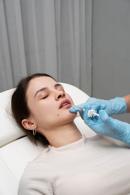 High angle woman getting lip fillers at clinic