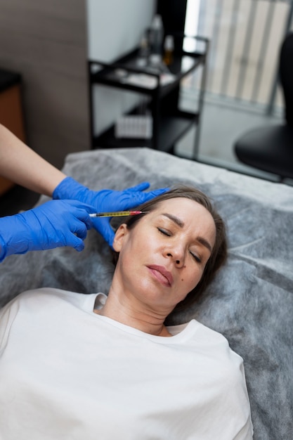 Free photo high angle woman getting prp injection