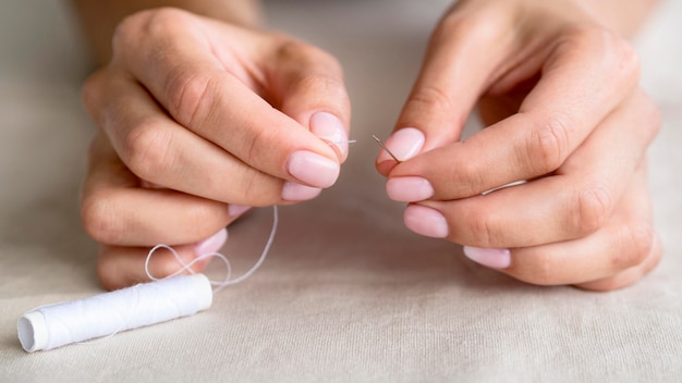 High angle of woman getting thread into needle