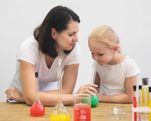 High angle woman and girl checking experiment