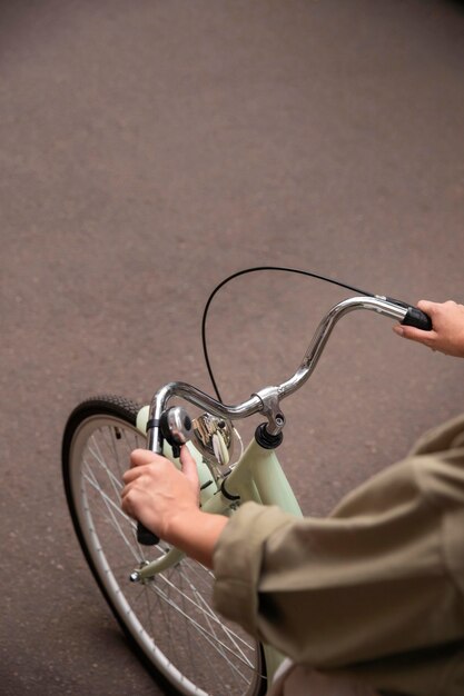 High angle of woman holding bicycle's handlebars