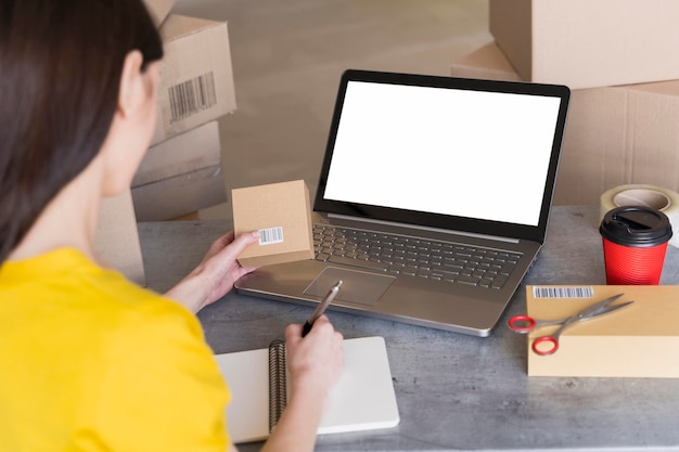 Free photo high angle of woman holding box with bar code and working